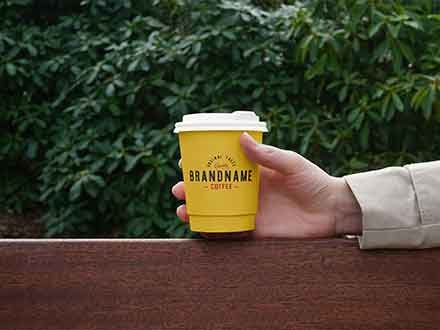 free-hand-holding-coffee-cup-mockup-(psd)